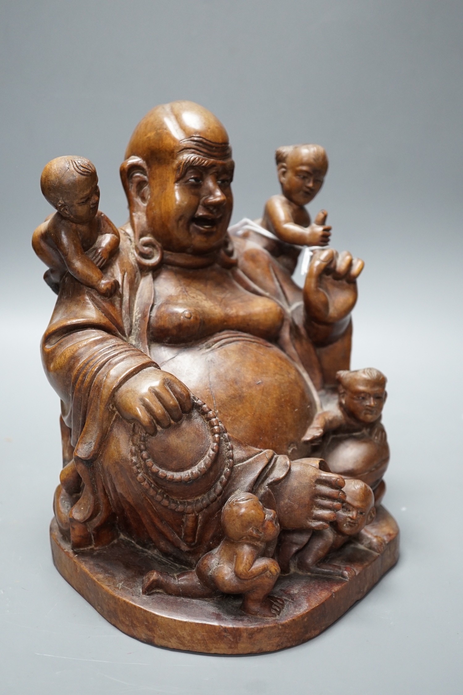 A Chinese carved wood group of Budai, 24cm